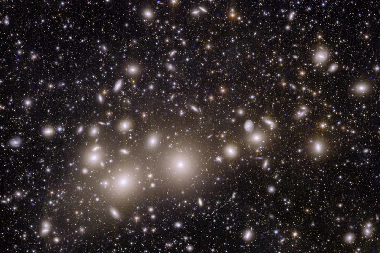 Astronomical image showing thousands of galaxies across the black expanse of space. The closest thousand or so galaxies belong to the Perseus Cluster. 